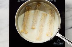 corn on the cob is being cooked in a saucepan with water and other ingredients