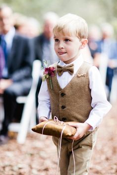 a young boy wearing a vest and bow tie