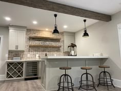 a kitchen with three bar stools next to an island