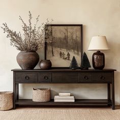 a wooden table topped with vases filled with flowers and other items next to a painting