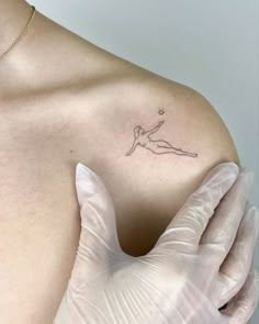 a person with gloves on their hands and a tattoo on their shoulder that has a woman's body in the shape of a star