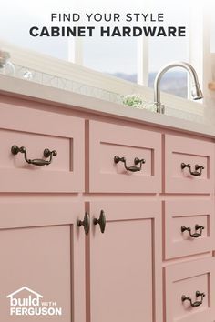 the cabinets are painted pink with black handles and pulls on them, which also have knobs