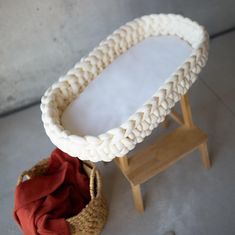 a basket sitting on the floor next to a small table with a cloth in it