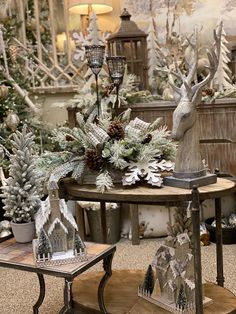 christmas decorations are displayed on tables in a room with trees and other holiday decor items