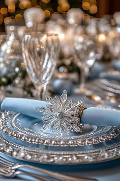 the table is set with silverware and blue napkins for an elegant christmas dinner