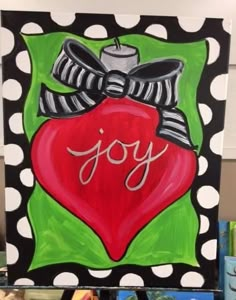 a painting that says joy with a red heart and bow on it's side