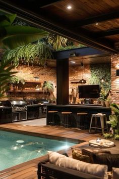 an outdoor kitchen and living room with a pool