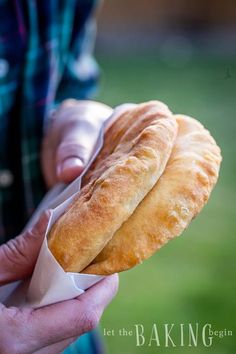 two croissants are being held in their hands