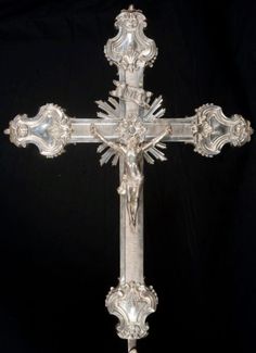 an ornate silver cross on a black background