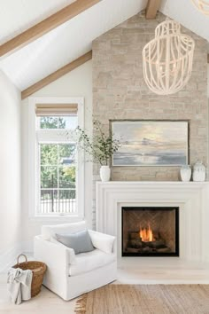 a living room filled with furniture and a fire place under a chandelier hanging from the ceiling