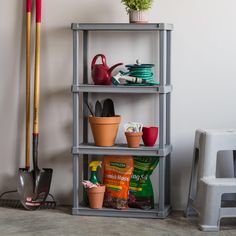 a shelf filled with pots and gardening tools on top of a floor next to a chair