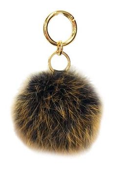 a key chain with a fur ball hanging from it's center loop, on a white background