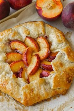 a peach pie with slices cut out on parchment paper