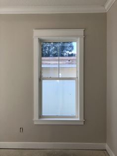 an empty room with a window in the middle and no curtains on the windowsill