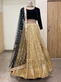 Elevate your style quotient with our exquisite Gold Net Lehenga Blouse. This handcrafted ensemble is designed to make you stand out at special occasions, be it a wedding, festive celebration, or any glamorous event. Key Features: Material: Lehenga Crafted from high-quality Embroidered net. Blouse is made of velvet fabric. Dupatta is in net. Design: The blouse features a timeless design with a sweetheart neckline. Color: Gold Lehenga and black blouse. Care Instructions: To ensure the longevity of this beautiful piece, we recommend dry cleaning only. Net Lehenga Blouse, Gold Lehenga, Net Blouse, Net Design, Black Long Sleeve Blouse, Net Lehenga, Lehenga Blouse, Black Blouse Long Sleeve, Embroidered Dupatta