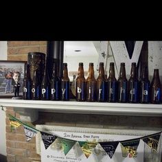 there are many beer bottles on the mantle