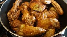 chicken wings are cooking in a pan on the stove