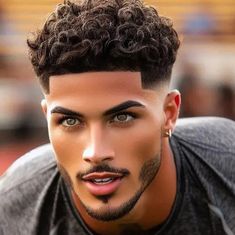 a close up of a person with a short haircut and curly hair wearing a black t - shirt