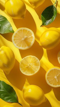 several lemons and leaves on a yellow background