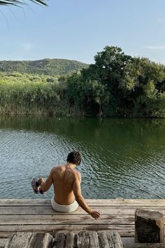 a person sitting on a dock looking at the water