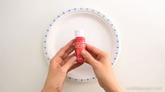 a person is holding a bottle of hand sanitizer in front of a plate