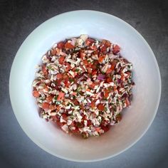 a white bowl filled with chopped vegetables on top of a table