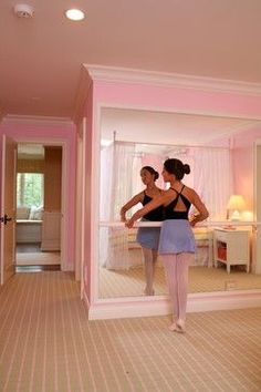 two women standing in front of a mirror with their backs turned to the opposite direction