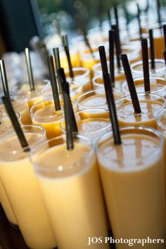 there are many glasses with drinks in them on the table and one is filled with orange juice