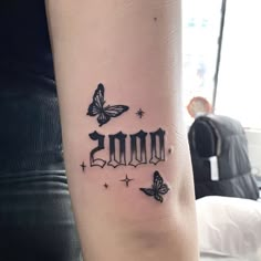 a woman's arm with a tattoo that reads 2010 and butterflies