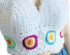 a woman wearing a crochet top with colorful circles on it