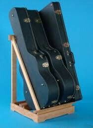 three guitar cases are sitting on a wooden stand