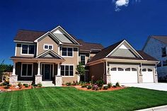 a large house with two garages and lots of grass in front of the house