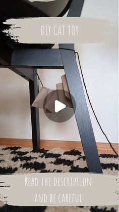 a cat toy sitting on top of a black chair next to a white wall with text reading diy cat toy read the description and be careful