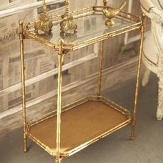 a glass shelf with two candles on it in front of a newspaper rack and chair