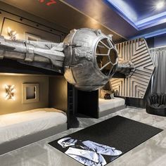 a room with bunk beds and a space shuttle on the wall in it's center