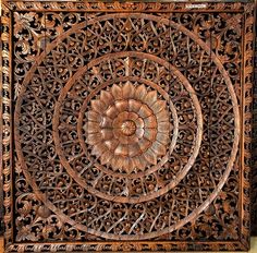 an intricately carved wooden panel with flowers and leaves on the center, is shown