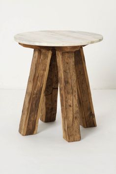 two wooden stools sitting next to each other on a white surface with one leg up