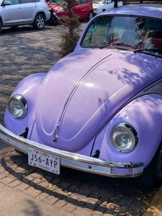 a purple vw bug is parked on the street