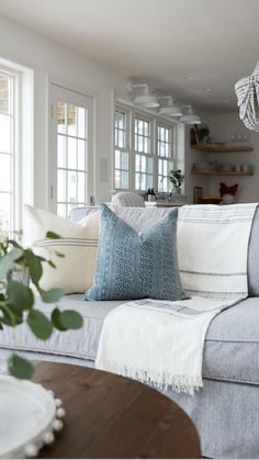 a living room filled with furniture and a chandelier hanging over the top of it