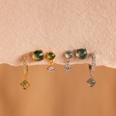 Tres aretes individuales combinan armoniosamente en nuestro juego de aretes de ágata. El exclusivo diseño verde arremolinado de la piedra Ágata crea una nueva apariencia cada vez que las usas. Con un arete de aro, un arete y un arete de gota, puedes usarlos todos juntos o dividirlos entre las orejas. Pase lo que pase, siempre tendrás una apariencia única que lucir.

 Este anuncio se puede comprar como un juego de 3 aretes individuales o como un juego completo de 3 pares de aretes (Ahorre 10%). P Elegant Green Natural Stone Hoop Earrings, Green Agate Gemstone Earrings, Green Moss Agate Earrings For Gift, Hoops With Charms, Initial Tag Necklace, Sideways Initial Necklace, Dainty Initial Necklace, Agate Earrings, Stud Set