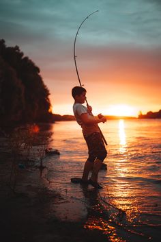 a man standing in the water with a fishing rod