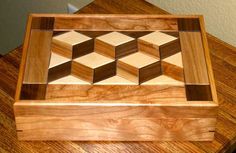 a wooden box sitting on top of a table filled with lots of wood cubes