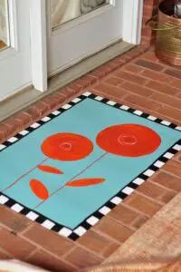 a door mat with an orange flower on it