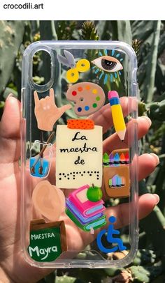 someone is holding up their phone case with magnets on it and writing in spanish