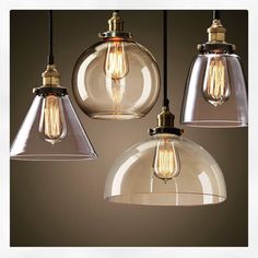 three clear glass pendant lights hanging from a ceiling fixture with one light bulb turned on