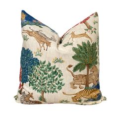 a decorative pillow with animals and trees on it