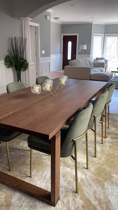 a large wooden table with green chairs around it