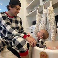 a man sitting next to a baby in a bath tub