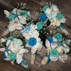 the bridal bouquets have blue and white flowers on them, along with seashells