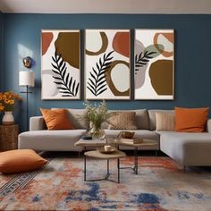 a living room with blue walls and orange pillows on the couches in front of two paintings